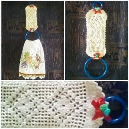 Porta Pano de Prato feito em crochê, finalizado com dois arcos de cor azul, detalhe para a flor de crochê presa a uma fita vermelha